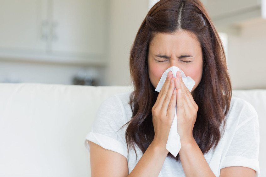 image of woman sneezing from allergies